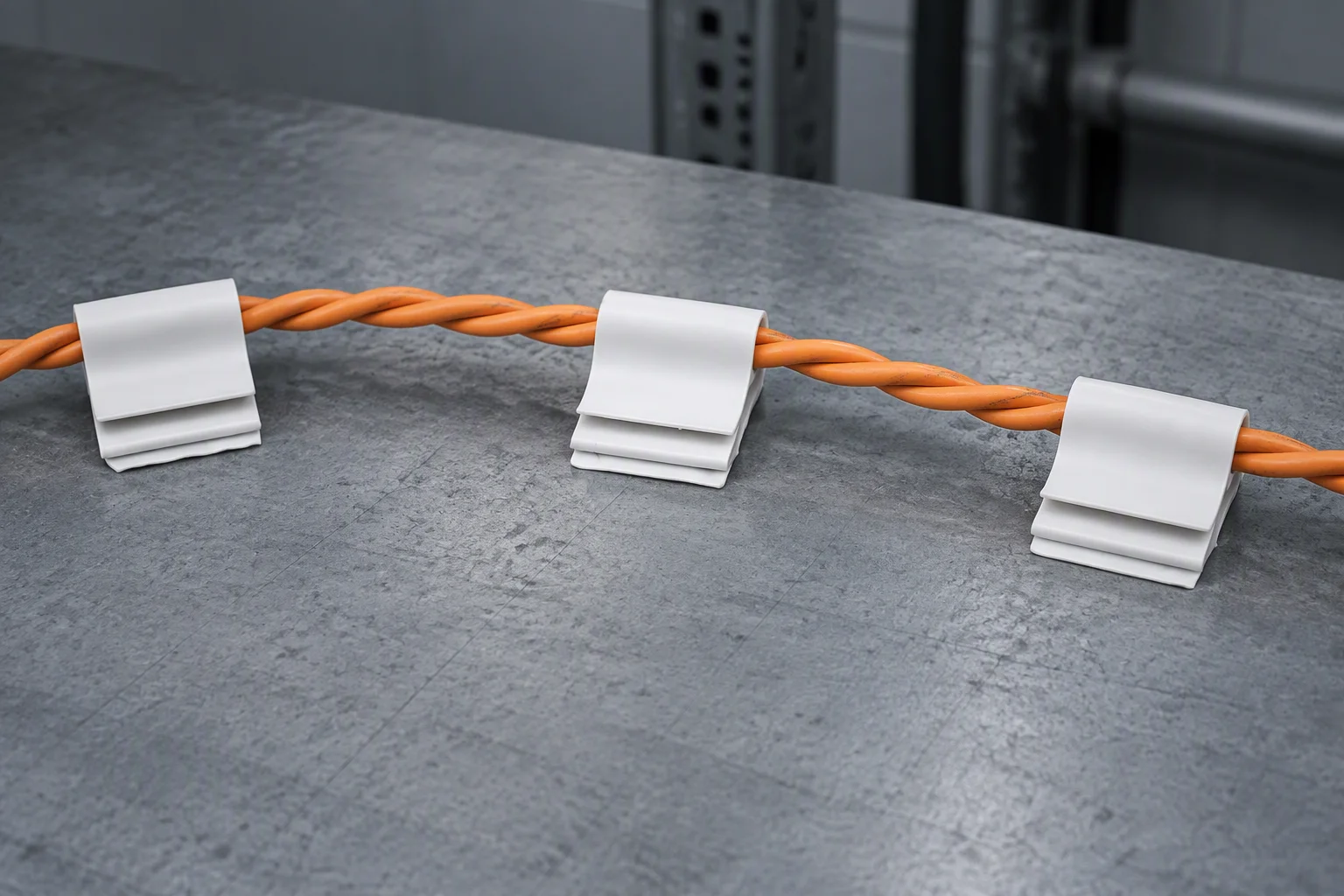 An under-floor cable run secured with clips, seen from above
